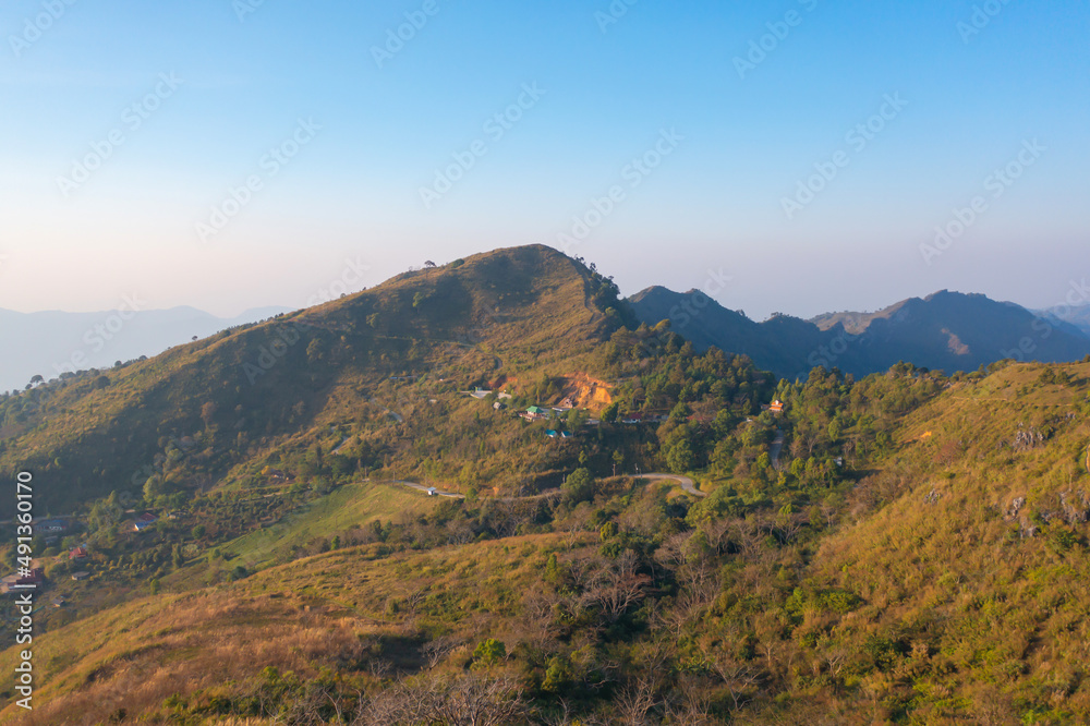 Aerial top view of forest trees and green mountain hills with fog, mist and clouds. Nature landscape background, Thailand.