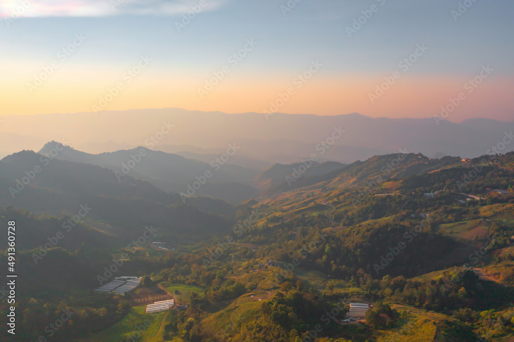 Aerial top view of forest trees and green mountain hills with fog, mist and clouds. Nature landscape background, Thailand.