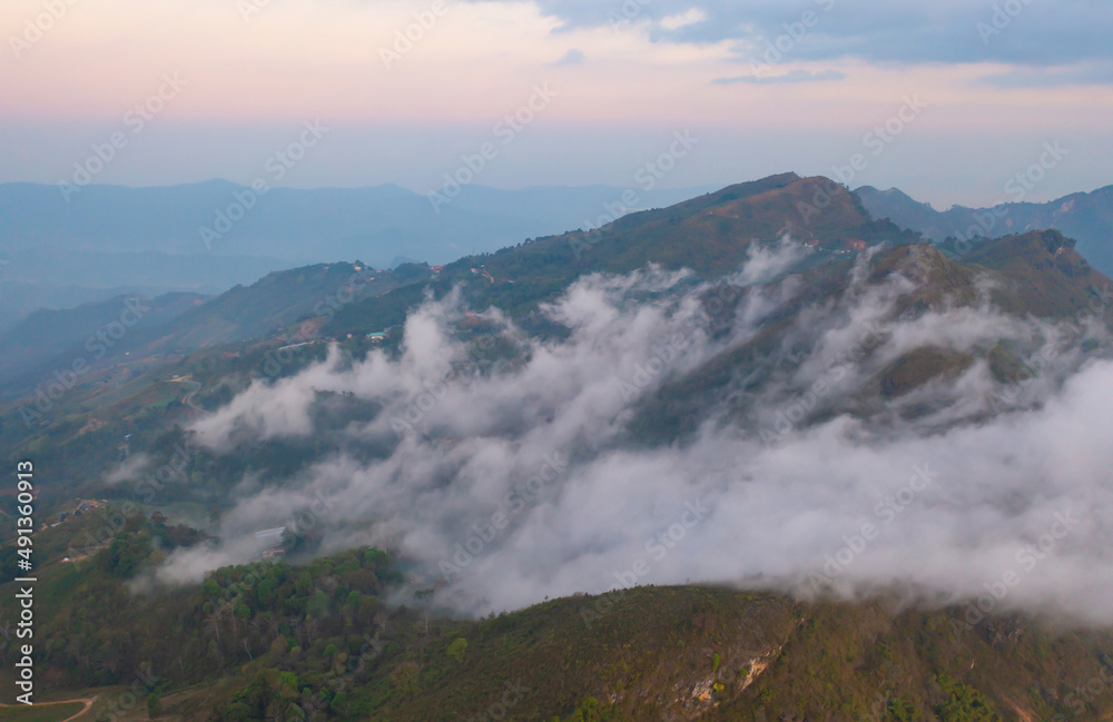 Aerial top view of forest trees and green mountain hills with fog, mist and clouds. Nature landscape background, Thailand.