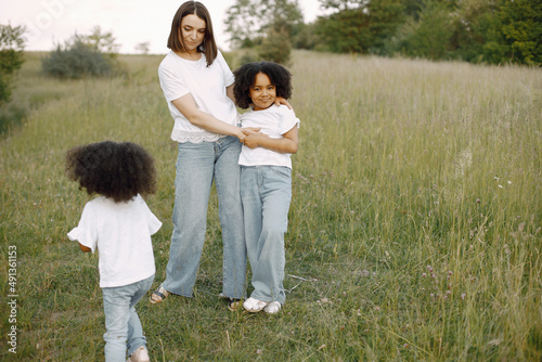 Caucasian mother embracing her mixed race daughters