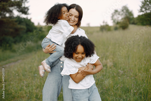 Caucasian mother embracing her mixed race daughters © prostooleh
