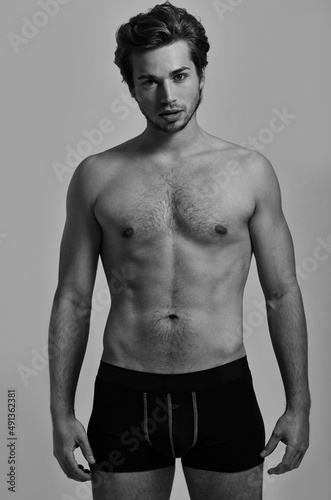 All this manliness. Studio portrait of a handsome young man posing in his underwear- monochrome.