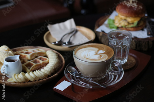 Beef burger served with Tuna toast, potato fries, blueberry waffle and hot coffee