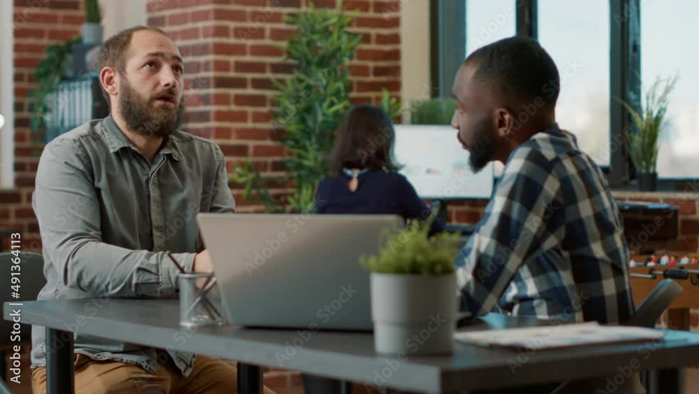 Applicant meeting with HR employee to talk about hiring and job offer, having conversation about recruitment and career opportunity. Male candidate attending job interview with recruiter. Applicant meeting with HR employee to talk about hiring and job offer, having conversation about recruitment and career opportunity. Male candidate attending job interview with recruiter.
