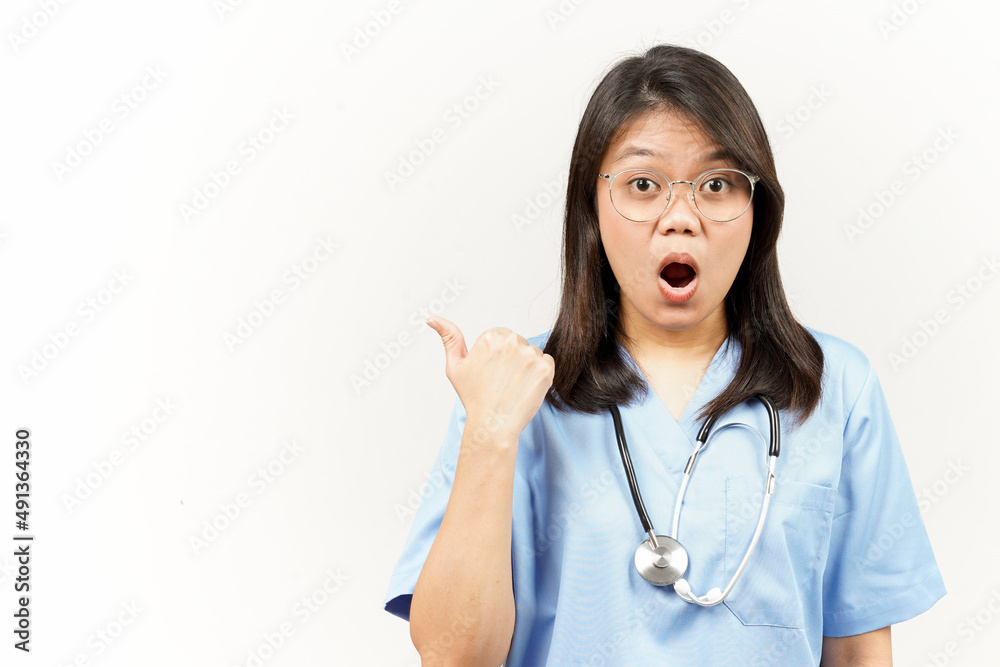 Showing and Pointing Product With Thumb Of Asian Young Doctor Isolated On White Background Showing and Pointing Product With Thumb Of Asian Young Doctor Isolated On White Background