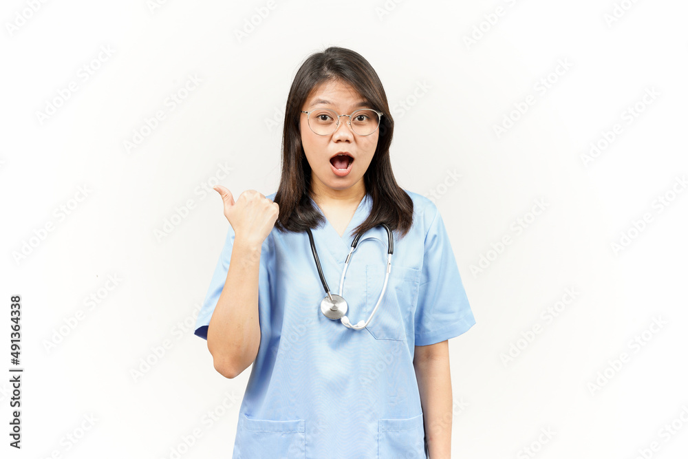Showing and Pointing Product With Thumb Of Asian Young Doctor Isolated On White Background Showing and Pointing Product With Thumb Of Asian Young Doctor Isolated On White Background