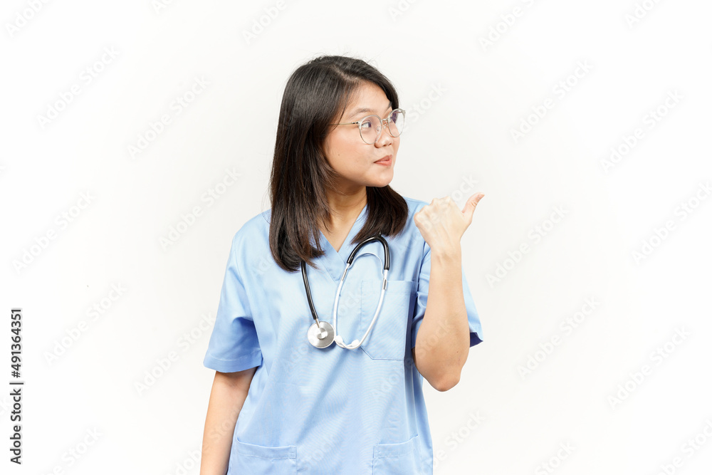 Showing and Pointing Product With Thumb Of Asian Young Doctor Isolated On White Background Showing and Pointing Product With Thumb Of Asian Young Doctor Isolated On White Background