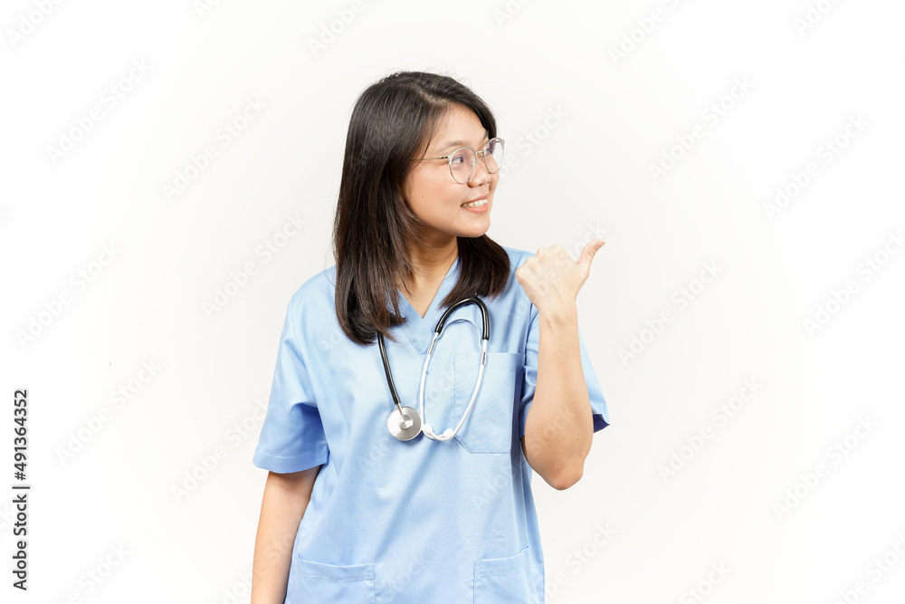 Showing and Pointing Product With Thumb Of Asian Young Doctor Isolated On White Background Showing and Pointing Product With Thumb Of Asian Young Doctor Isolated On White Background