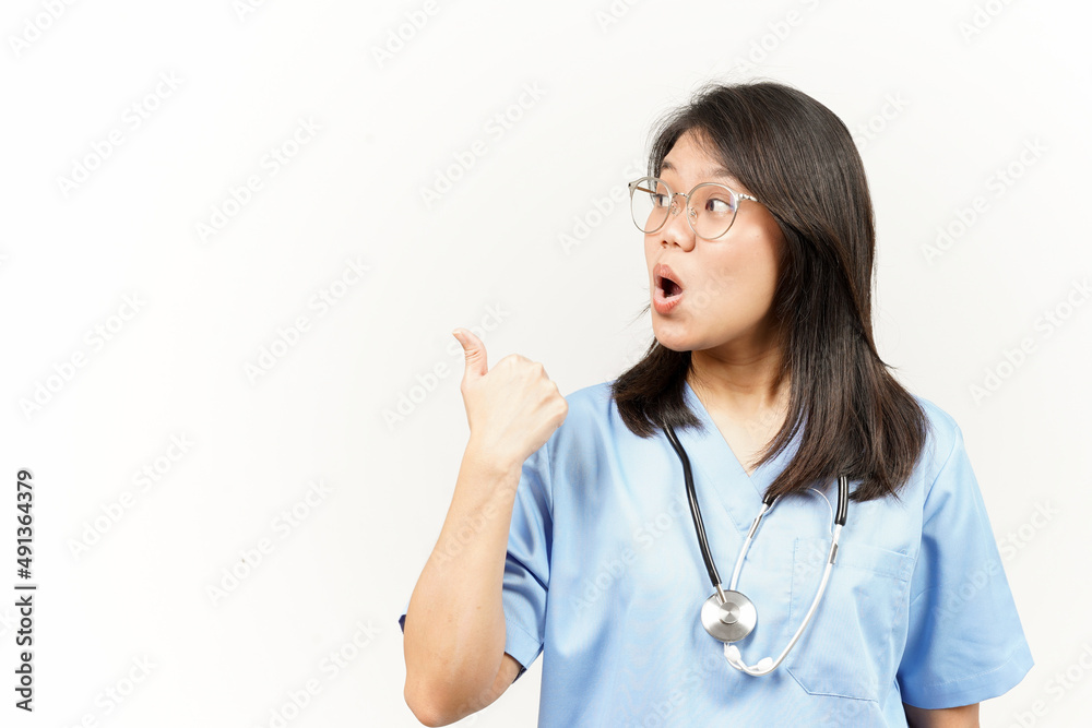 Showing and Pointing Product With Thumb Of Asian Young Doctor Isolated On White Background Showing and Pointing Product With Thumb Of Asian Young Doctor Isolated On White Background