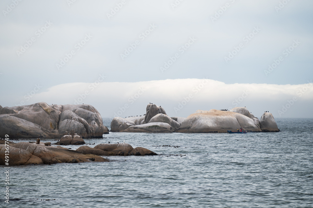 Fototapeta premium Ocean boulders with clouds in the background
