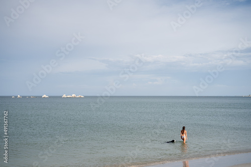Women and dog take a dip in the ocean