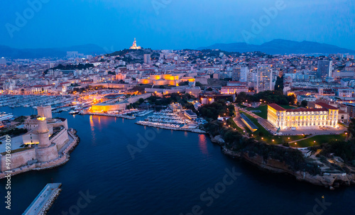 Aerial view of old port, Tour du Fanal and Basilica of Notre Dame at Marseille, France at night