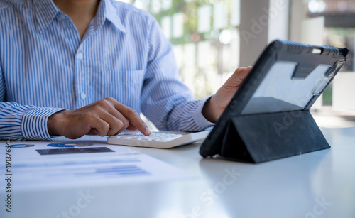 Businessman office worker sitting at a desk looking at tablet discussing working analyzing with financial data and marketing growth report graph