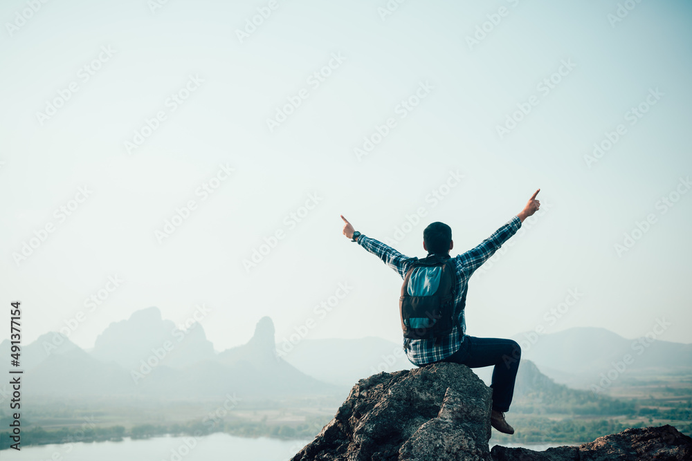 Success man hiker outstretched arms on top of the mountain .Concept of adventure travel Success man hiker outstretched arms on top of the mountain .Concept of adventure travel