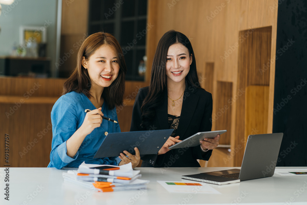 Close up happy young asian businesswoman using laptop with laughing female mentor in coworking boardroom at meeting. Smiling diverse woman managers talking about new business concept. Close up happy young asian businesswoman using laptop with laughing female mentor in coworking boardroom at meeting. Smiling diverse woman managers talking about new business concept.