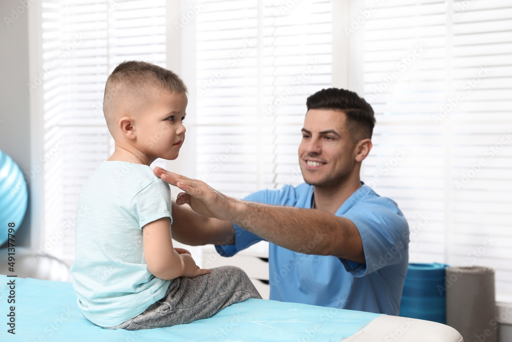 Orthopedist examining child in clinic. Scoliosis treatment Orthopedist examining child in clinic. Scoliosis treatment