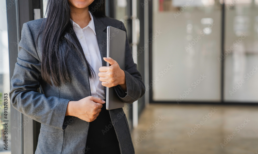 Naklejka premium woman in business clothes holding laptop computer