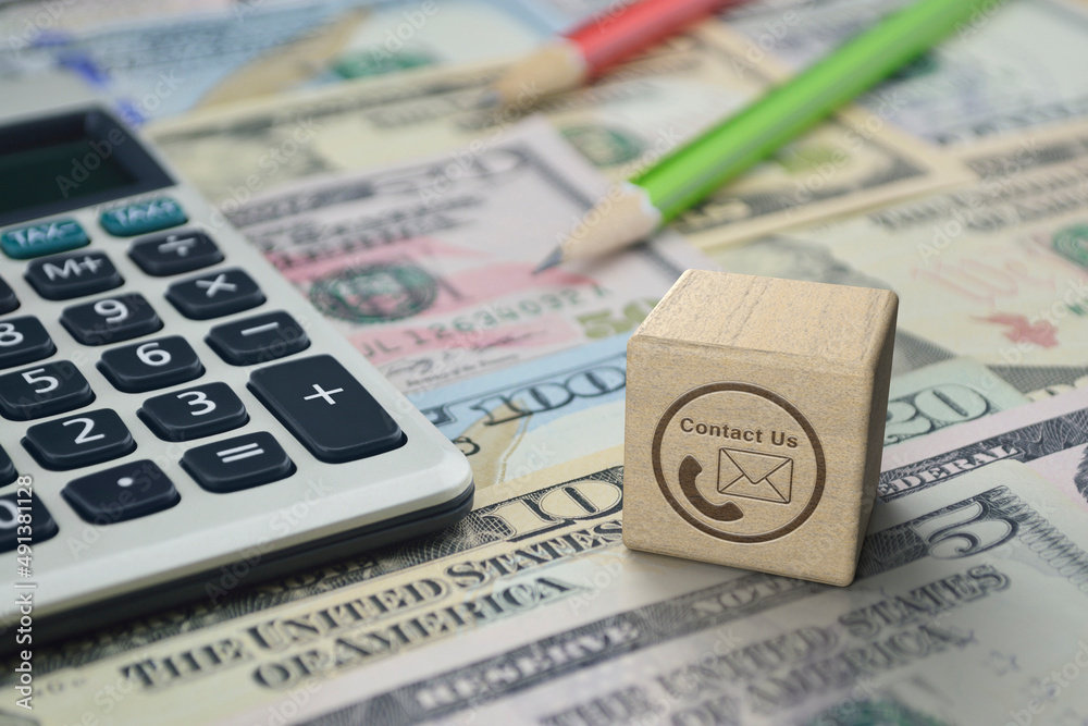 Fototapeta premium Telephone and email icon on wooden block cube with calculator and pencil on dollar bank note money, Business financial contact us online concept