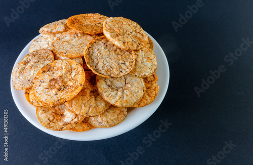 Brown rice chips on a plate against a dark background