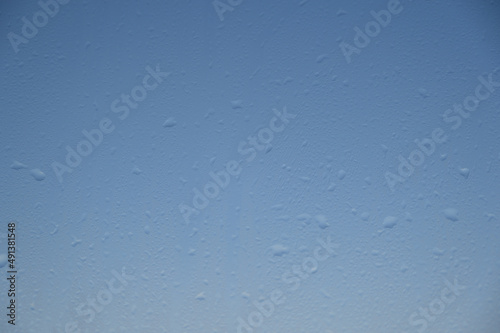 water drops on the window against the blue sky, rain on the glass