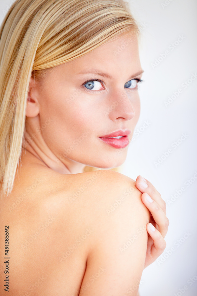 Naklejka premium My skin has never felt more beautiful. Beautiful young woman touching her skin against a white background.