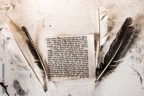 Mezuzah parchment made from animal skin with the full text of the Shema Yisrael prayer in Hebrew and the feather quills used to write the Hebrew text taken from the Bible. photo