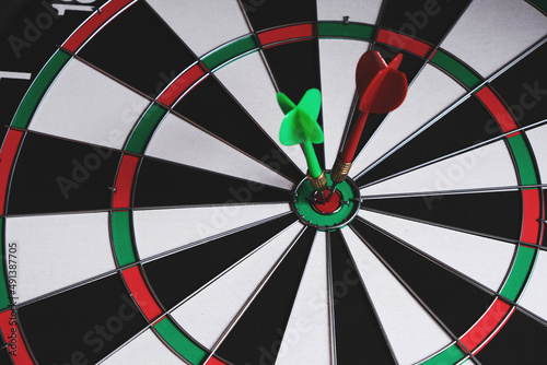 Dartboard with green dart stuck in center.