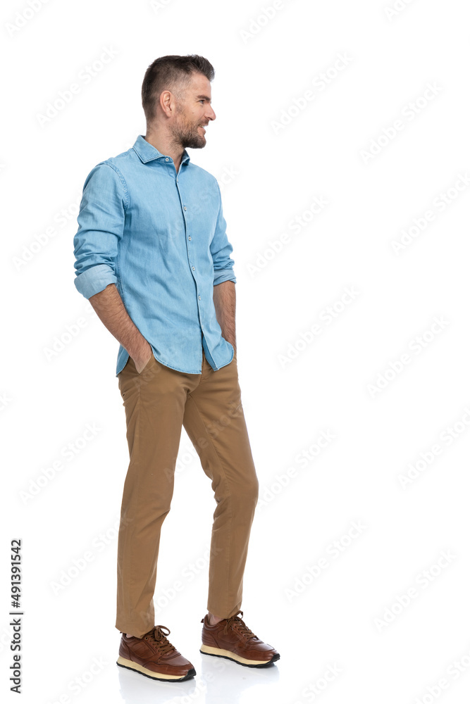 sexy grizzled man holding hands in pockets and looking to side