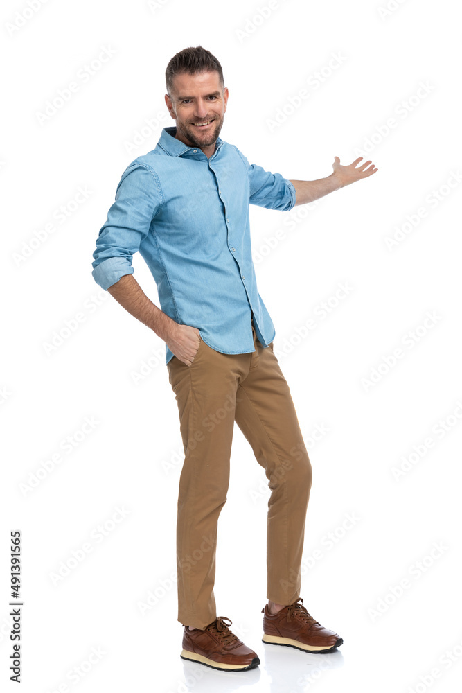 handsome bearded man with hand in pocket welcoming and inviting to side handsome bearded man with hand in pocket welcoming and inviting to side