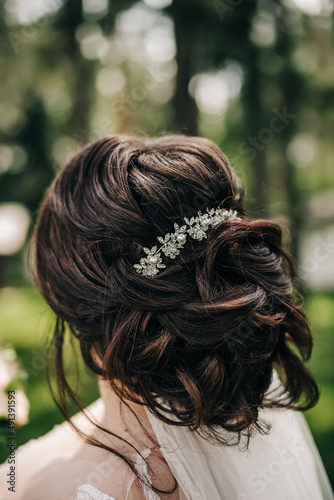 Stylish hairstyle with weaving and a hairpin on brown hair 
