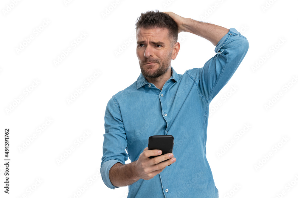 confused guy in blue jeans shirt scratching head and looking away confused guy in blue jeans shirt scratching head and looking away