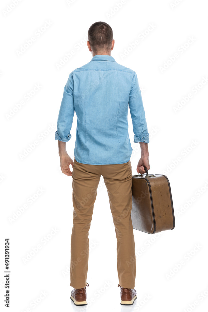 back view of casual man in his forties taking the luggage and leaving town for a work conference back view of casual man in his forties taking the luggage and leaving town for a work conference