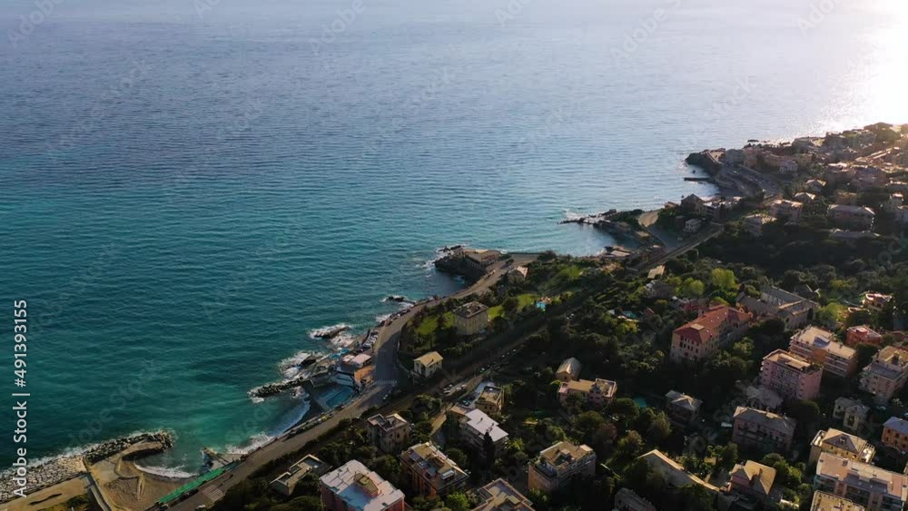 Aerial view overlooking villas at the shore of Quarto dei Mille, sunny Genova, Italy - tilt, drone shot