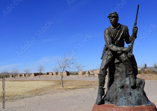 
 a buffalo soldier statue  at the nineteenth century  united states army post  of fort selden historic site near radium springs,  in dona ana county, new mexico, on a sunny winter day  photo