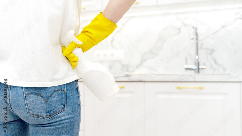 Beautiful woman in protective gloves cleaning kitchen cabinet Beautiful woman in protective gloves cleaning kitchen cabinet