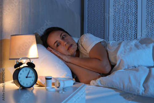 Mature woman suffering from insomnia in bed at night photo