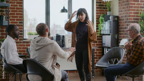 Obraz na plátně Woman having nervous breakdown in front of group at aa support therapy meeting