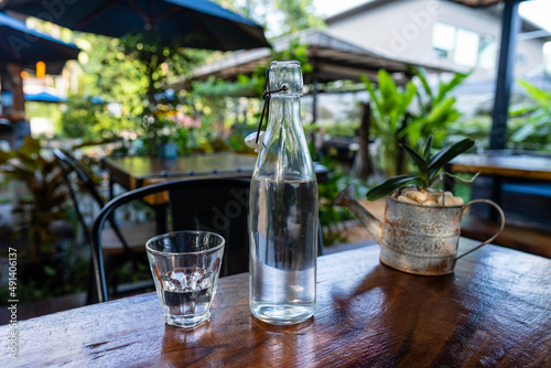 Bottle and glass with water on the wooden table