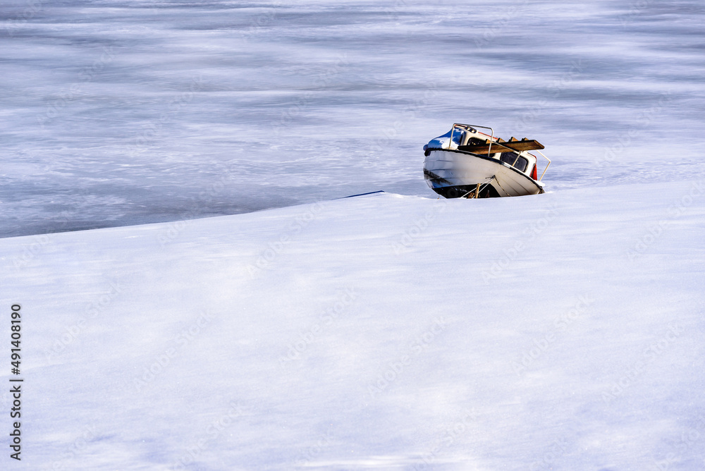 A boat on a frozen lake. Frozen Lake Vlasina - vlasinsko jezeto in Winter A boat on a frozen lake. Frozen Lake Vlasina - vlasinsko jezeto in Winter