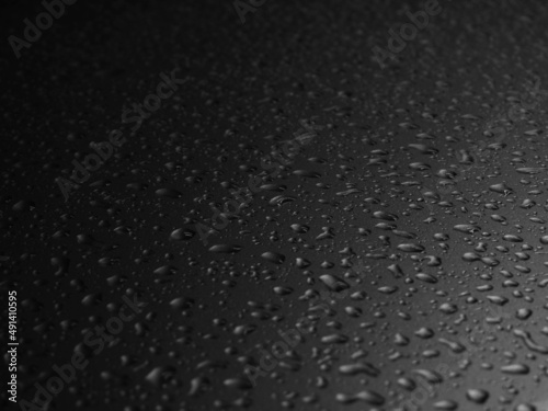 close up water drops on black car after rain