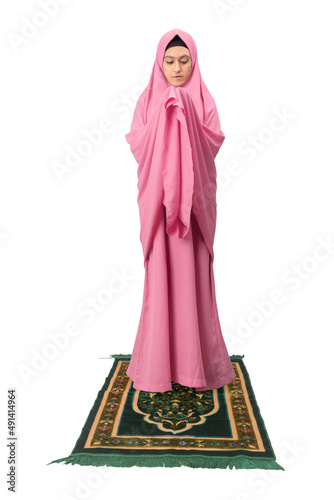 Asian Muslim woman in a veil standing while raised hands and praying