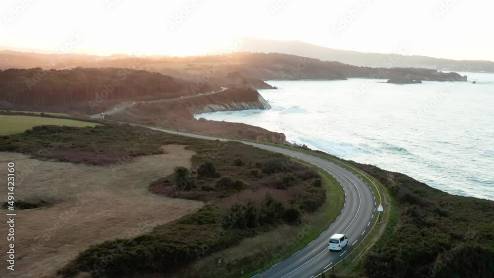 Drone video of a van driving along the ocean with a sunset. Drone video of a van driving along the ocean with a sunset.