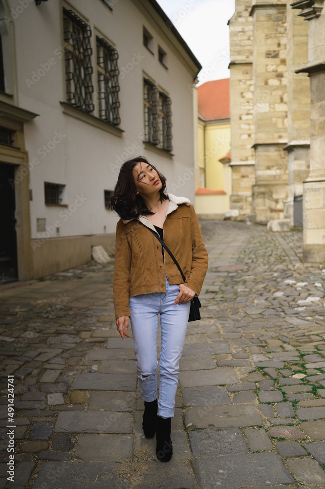 Young Asian woman walking at historic european city.