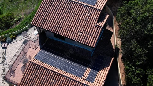 Aerial of modern house in Monrovia with solar panels, drone descending. photo