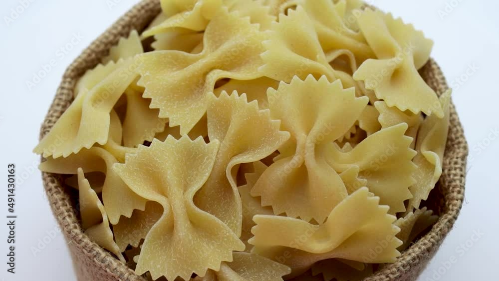 Pasta from durum wheat in a canvas bag on a white background. Close-up. Italian pasta. Pasta from durum wheat in a canvas bag on a white background. Close-up. Italian pasta.