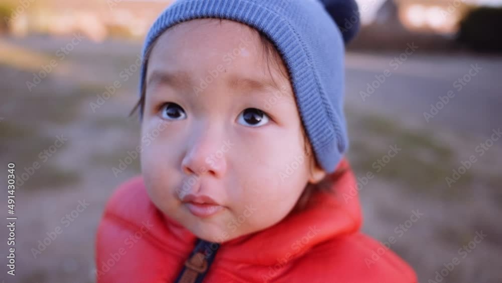 A close-up shot of a young Asian girl happy and looking towards the camera before she walks away. A close-up shot of a young Asian girl happy and looking towards the camera before she walks away.