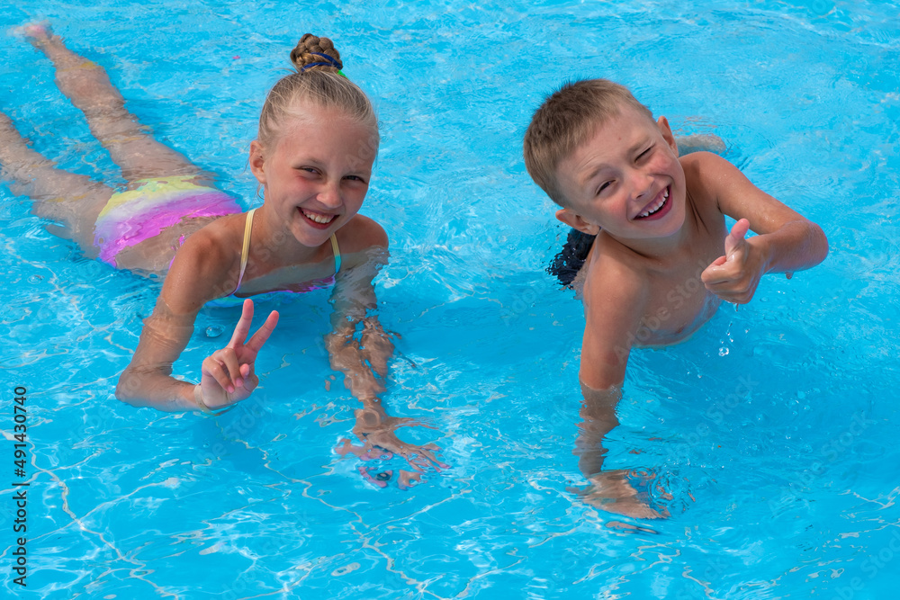 boy and girl having fun in the pool boy and girl having fun in the pool