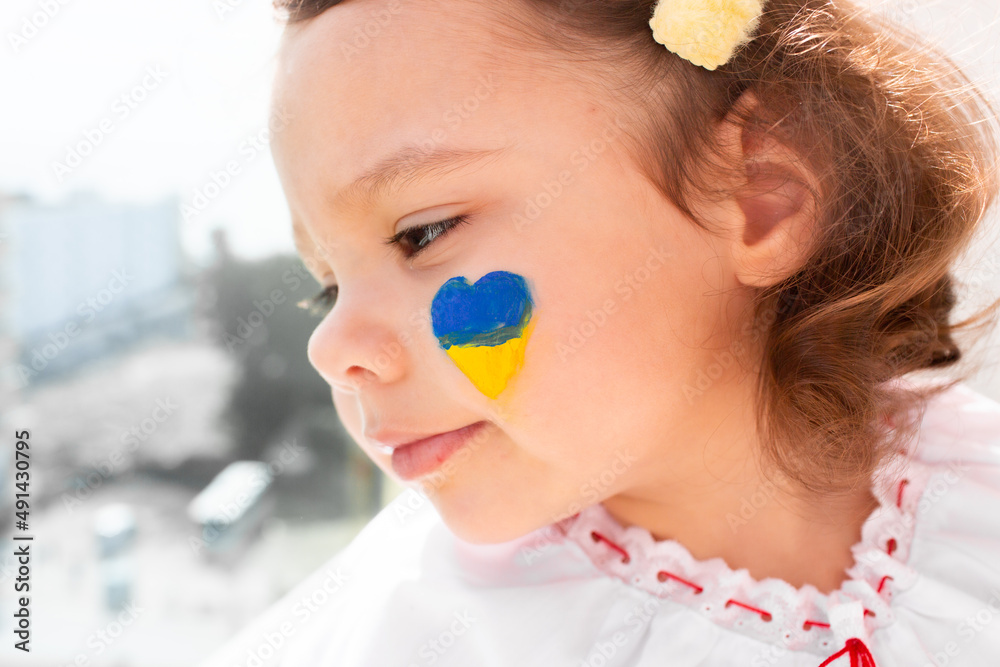 Little Ukrainian girl in an embroidered shirt on a white background. A little girl in national Ukrainian clothes - vyshyvanka. Little Ukrainian girl with a patriotic flag. Little Ukrainian girl in an embroidered shirt on a white background. A little girl in national Ukrainian clothes - vyshyvanka. Little Ukrainian girl with a patriotic flag.