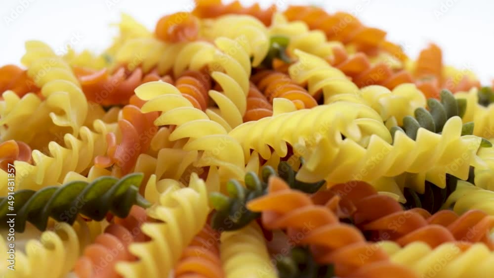 Three Colors Pasta made from durum wheat. Pasta fusilli tricolor background. Abstract texture of colorful pasta. pattern of macaroni. Bright multicolor food backdrop. Uncooked colored noodles. Three Colors Pasta made from durum wheat. Pasta fusilli tricolor background. Abstract texture of colorful pasta. pattern of macaroni. Bright multicolor food backdrop. Uncooked colored noodles.