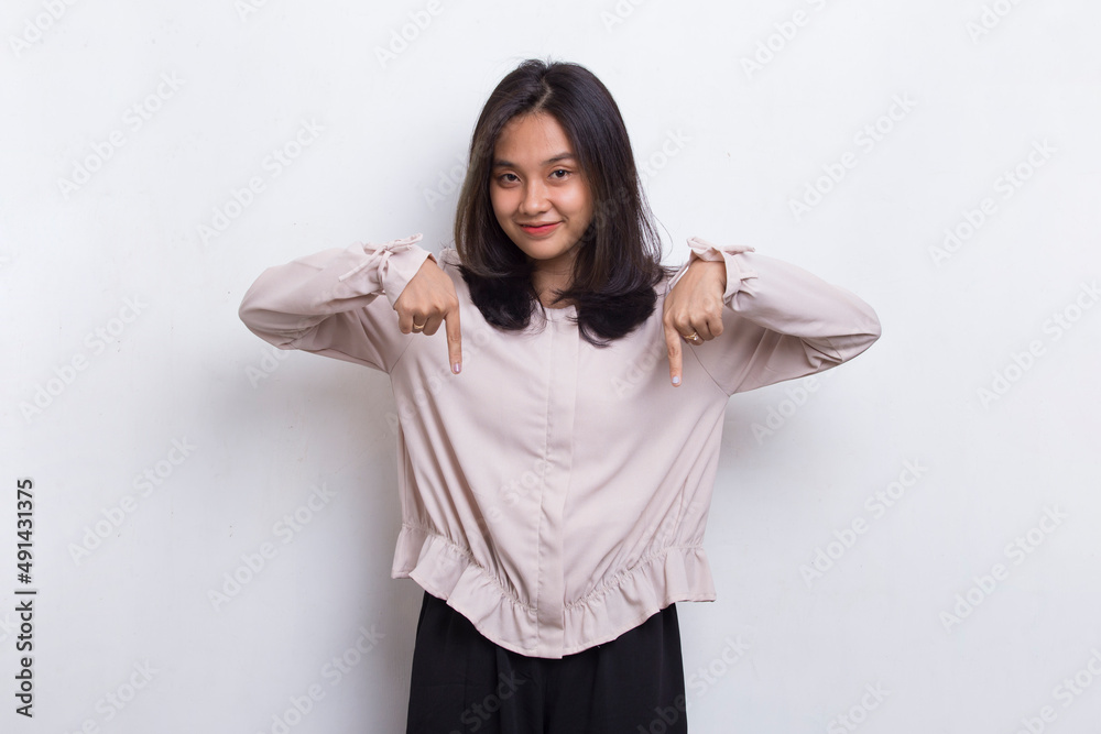 Happy young asian woman pointing with fingers to different directions isolated on white background
Happy young asian woman pointing with fingers to different directions isolated on white background